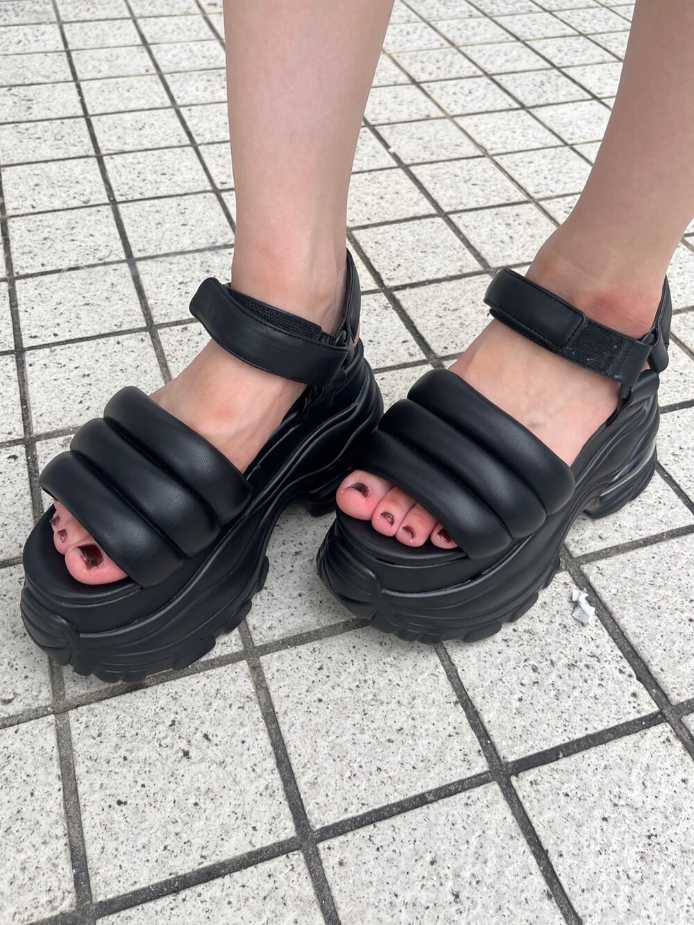 ブラック系のワンピース、ブルー系のデニムパンツ、ブラック系のサンダルを着用したレディースの夏コーディネートの5枚目の写真