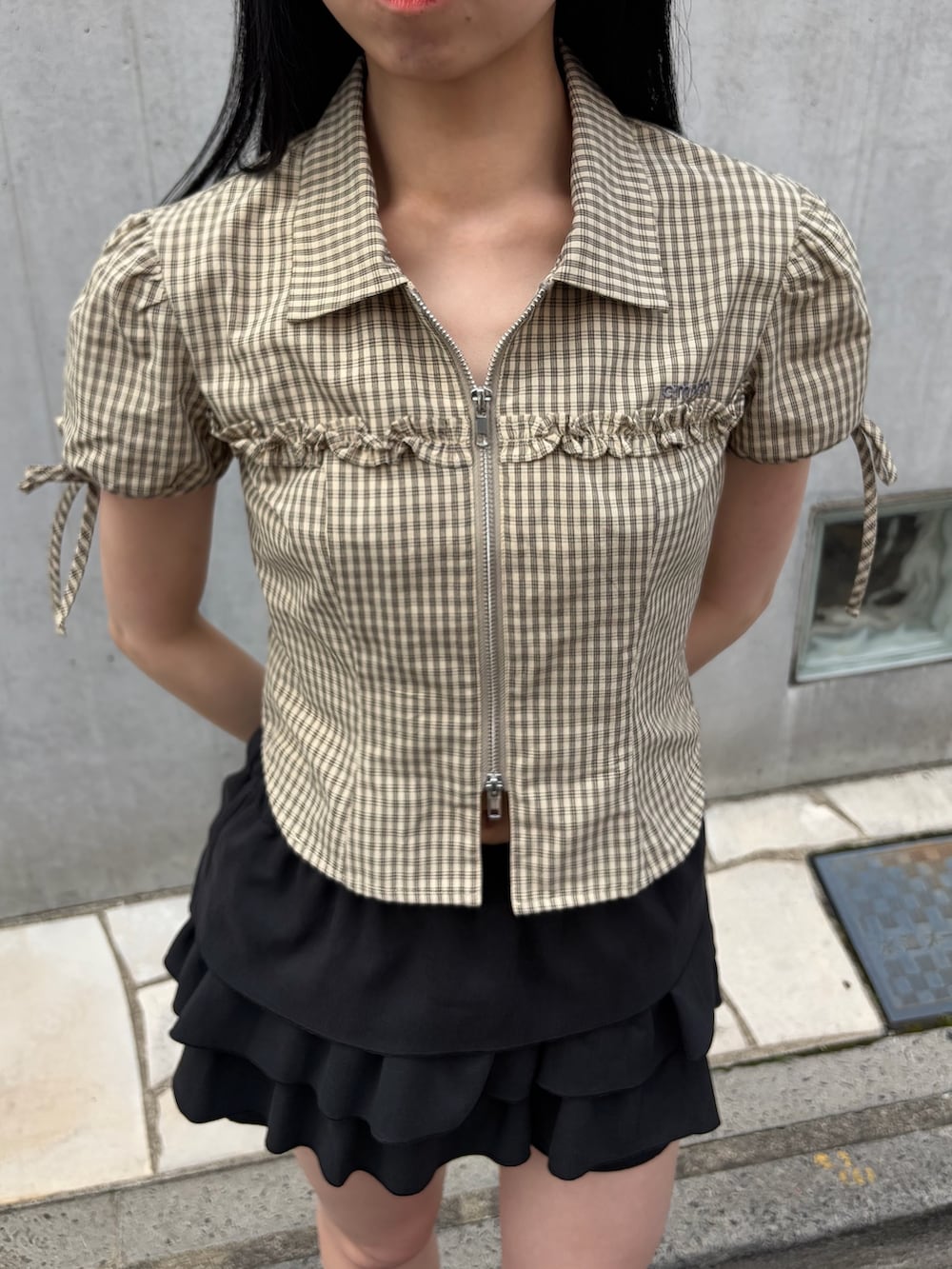 ベージュ系のシャツ/ブラウス、ブラック系のスカート、ブラック系のブーツを着用したレディースの春コーディネートの5枚目の写真
