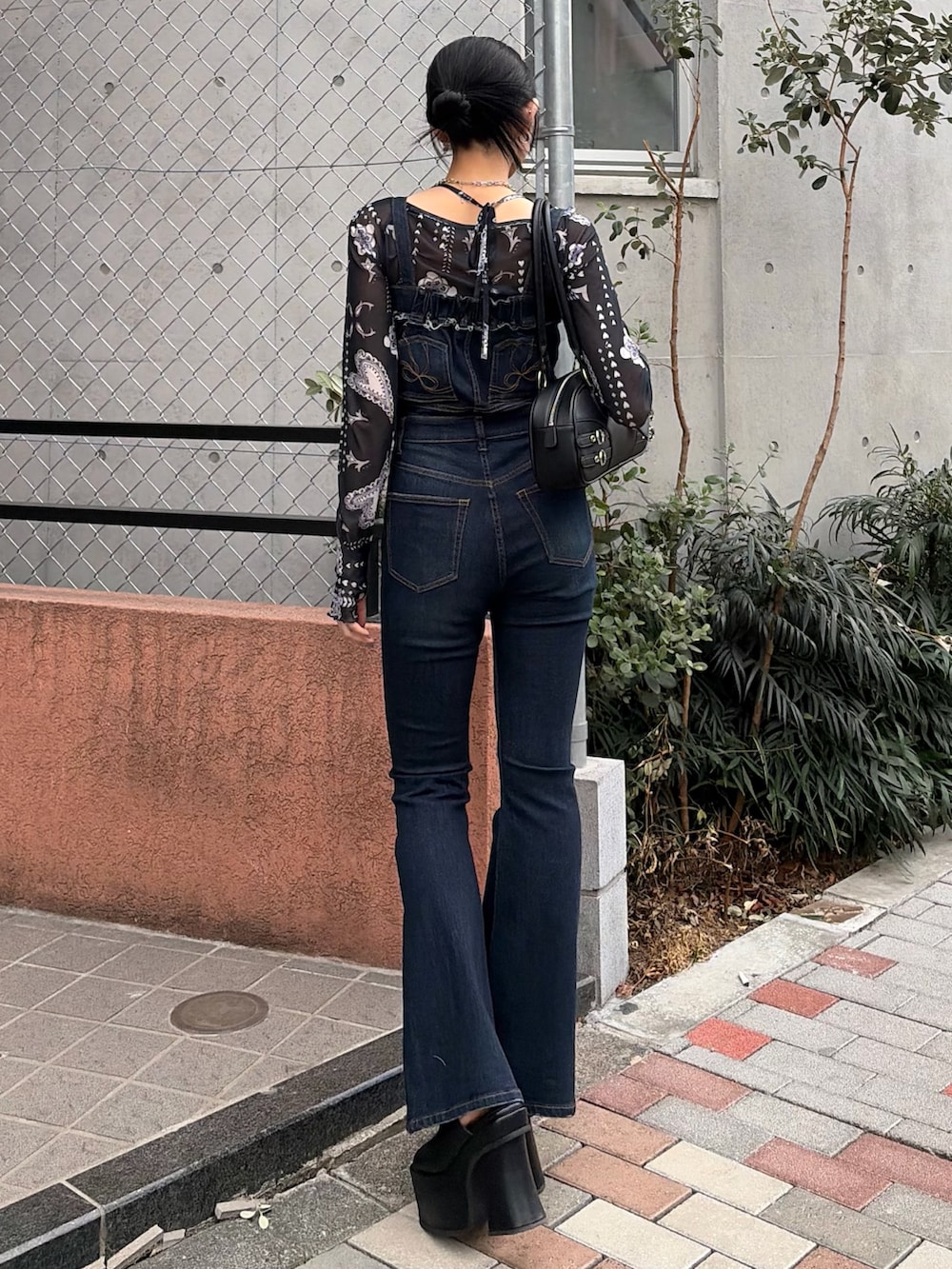 ブラック系のハンドバッグ、ブルー系のサロペット/オーバーオール、ブルー系のTシャツ/カットソーを着用したレディースの春コーディネートの3枚目の写真