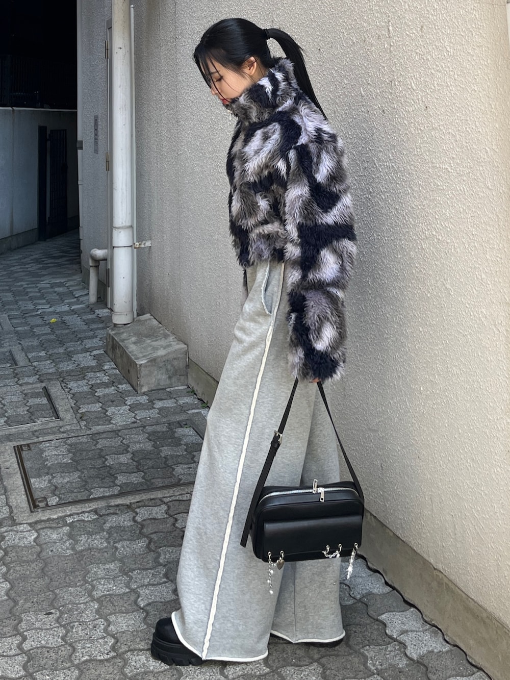 ブルー系のブルゾン、グレー系のスウェットパンツ、ブラック系のハンドバッグを着用したレディースの秋コーディネートの2枚目の写真