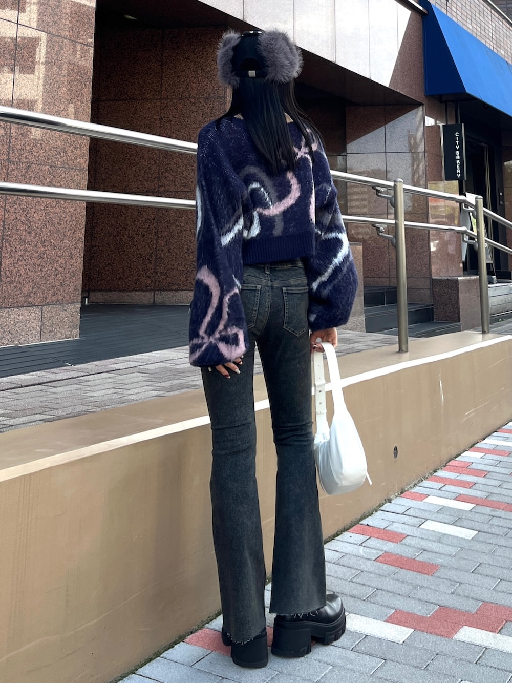 ブルー系のニット/セーター、ブルー系のデニムパンツ、ホワイト系のショルダーバッグを着用したレディースの秋コーディネートの2枚目の写真