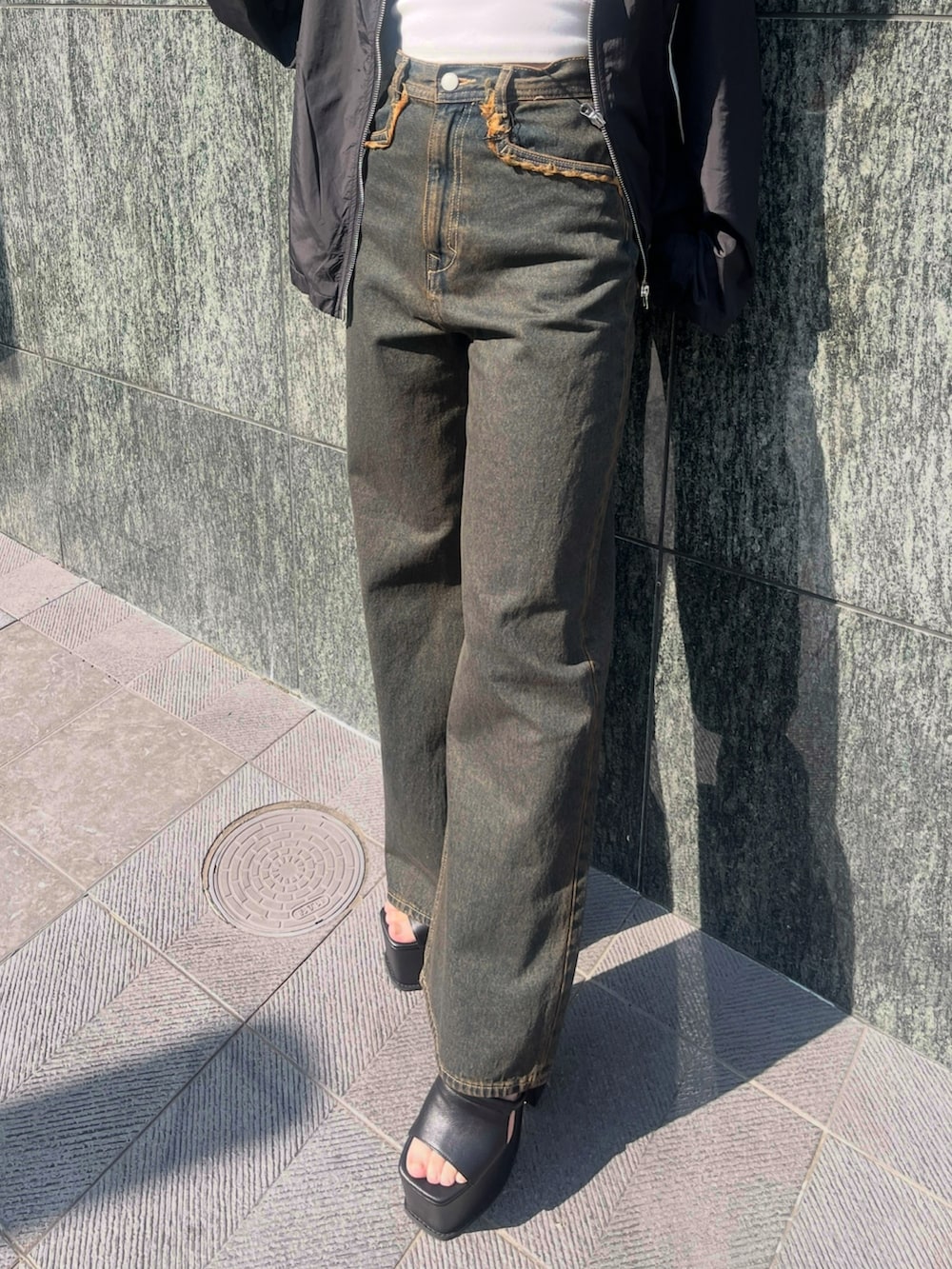 ブルー系のデニムパンツ、ブルー系のタンクトップ、ブラック系のTシャツ/カットソーを着用したレディースの春コーディネートの5枚目の写真