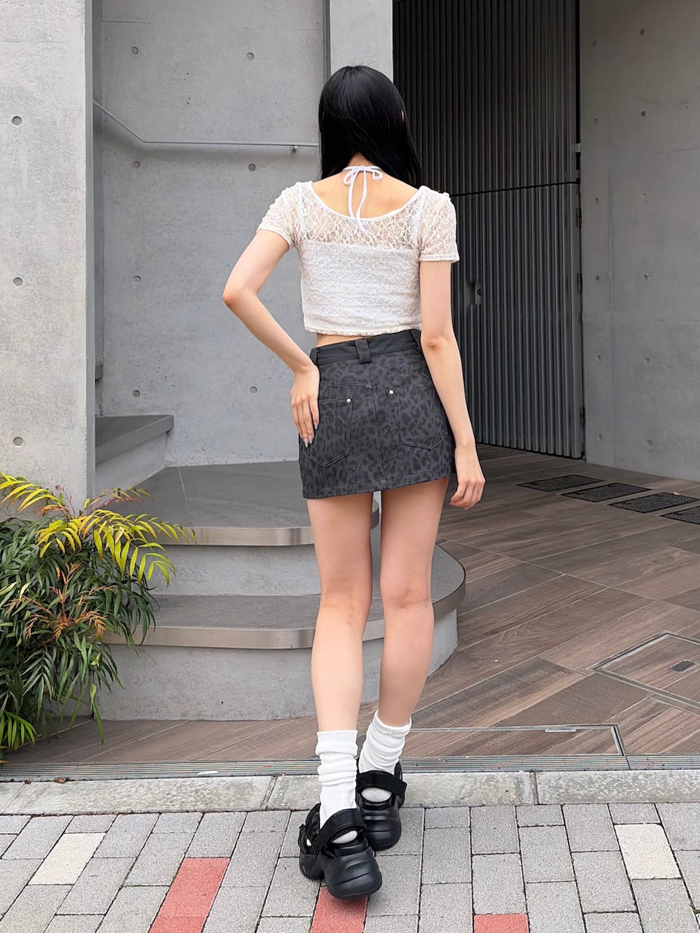 ホワイト系のTシャツ/カットソー、グレー系のスカート、ブラック系のサンダルを着用したレディースの夏コーディネートの2枚目の写真