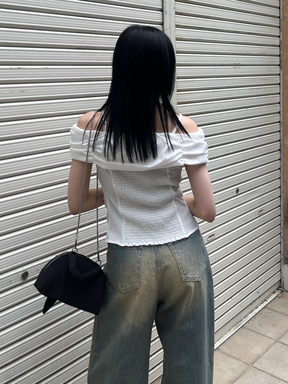 ホワイト系のTシャツ/カットソー、ブルー系のデニムパンツ、ブラック系のハンドバッグを着用したレディースの夏コーディネートの4枚目の写真