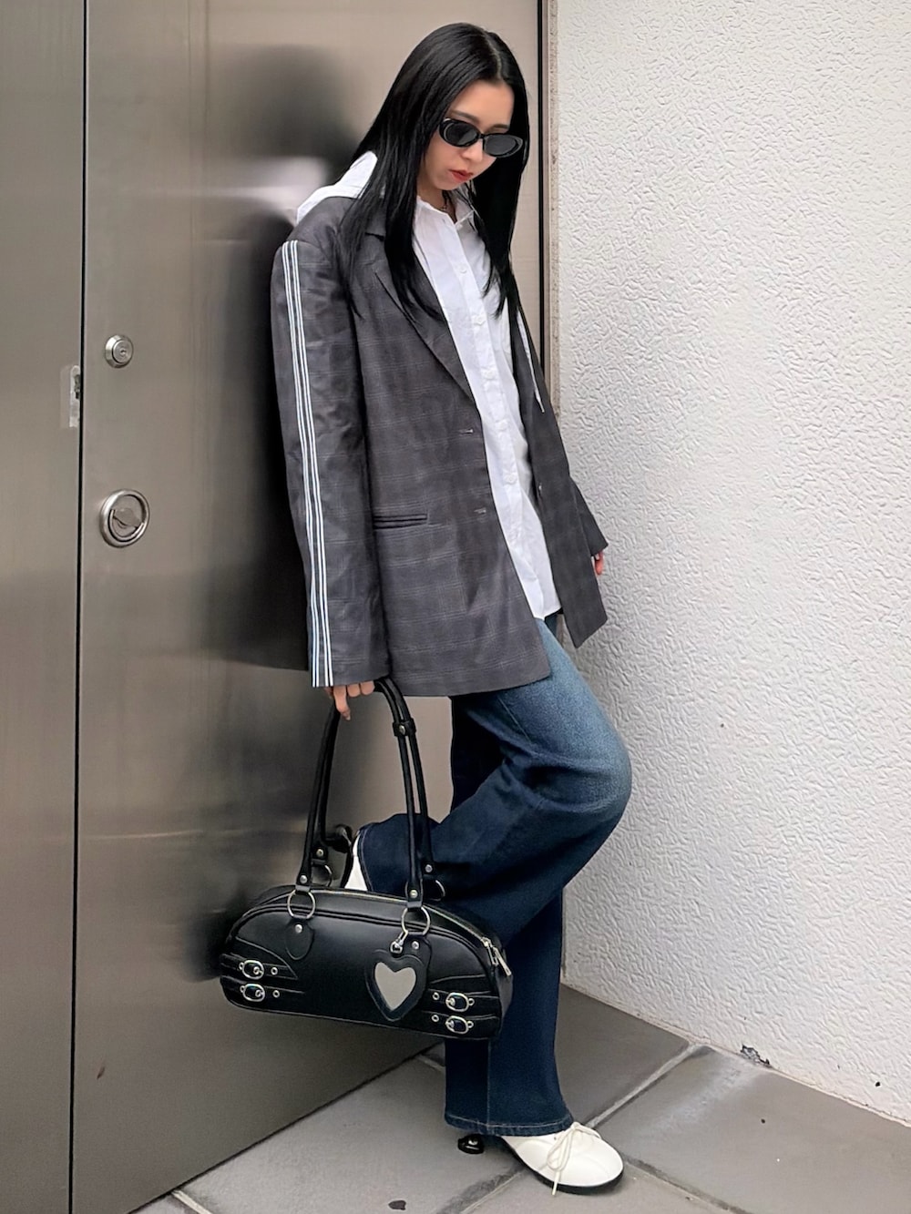 グレー系のテーラードジャケット、ホワイト系のシャツ/ブラウス、ブルー系のデニムパンツを着用したレディースの春コーディネートの2枚目の写真