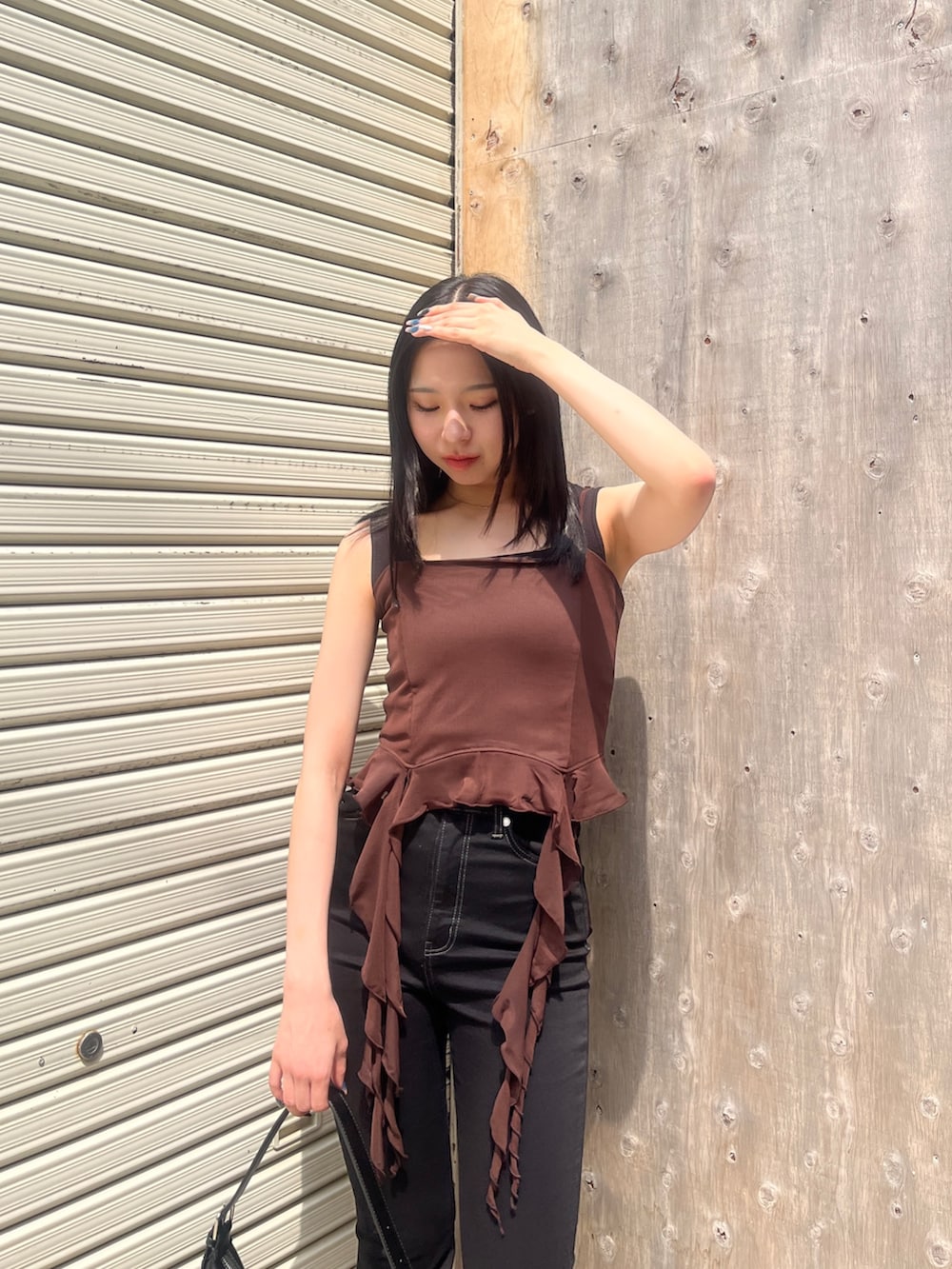 ブラック系のサロペット/オーバーオール、ブラック系のハンドバッグ、ブラック系のサンダルを着用したレディースの春コーディネートの3枚目の写真