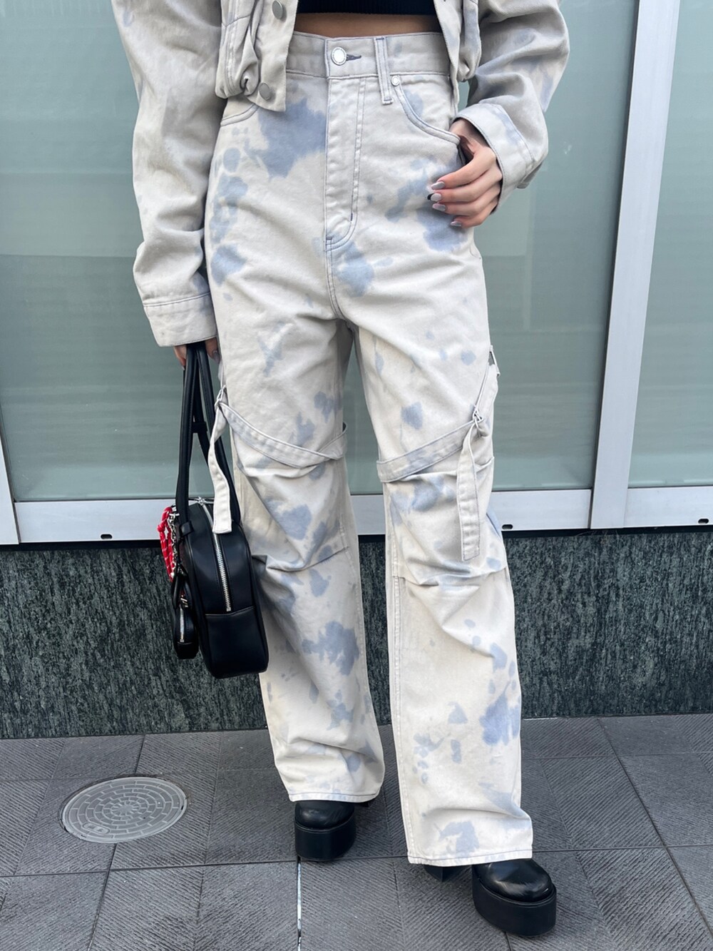 ホワイト系のデニムジャケット、ブラック系のニット/セーター、ホワイト系のデニムパンツを着用したレディースの冬コーディネートの5枚目の写真