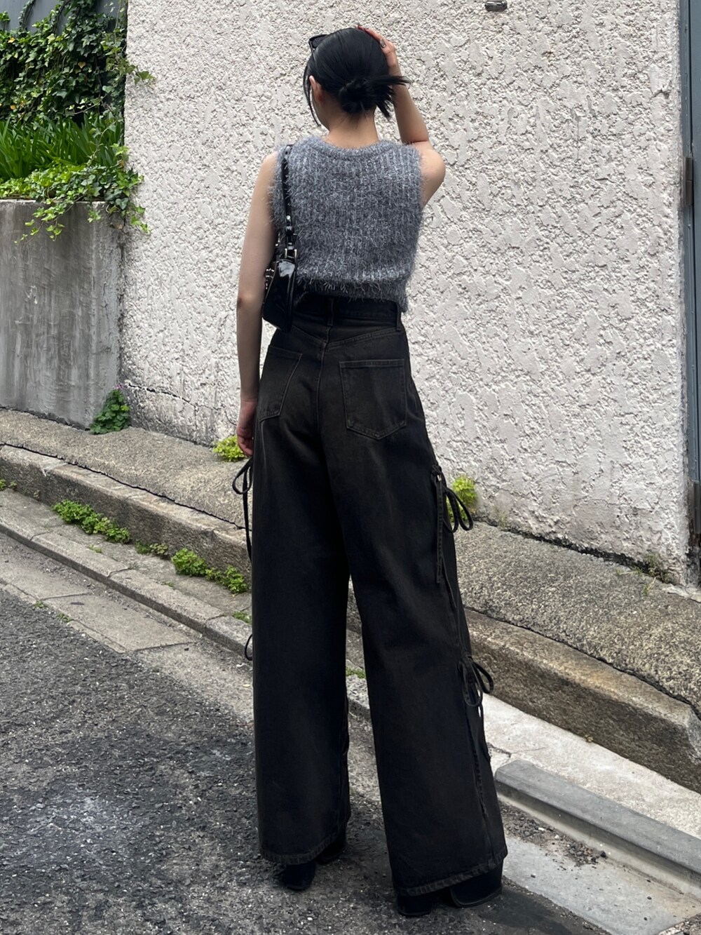 ブラック系のデニムパンツ、ブラック系のサンダル、グレー系のニット/セーターを着用したレディースの春コーディネートの3枚目の写真