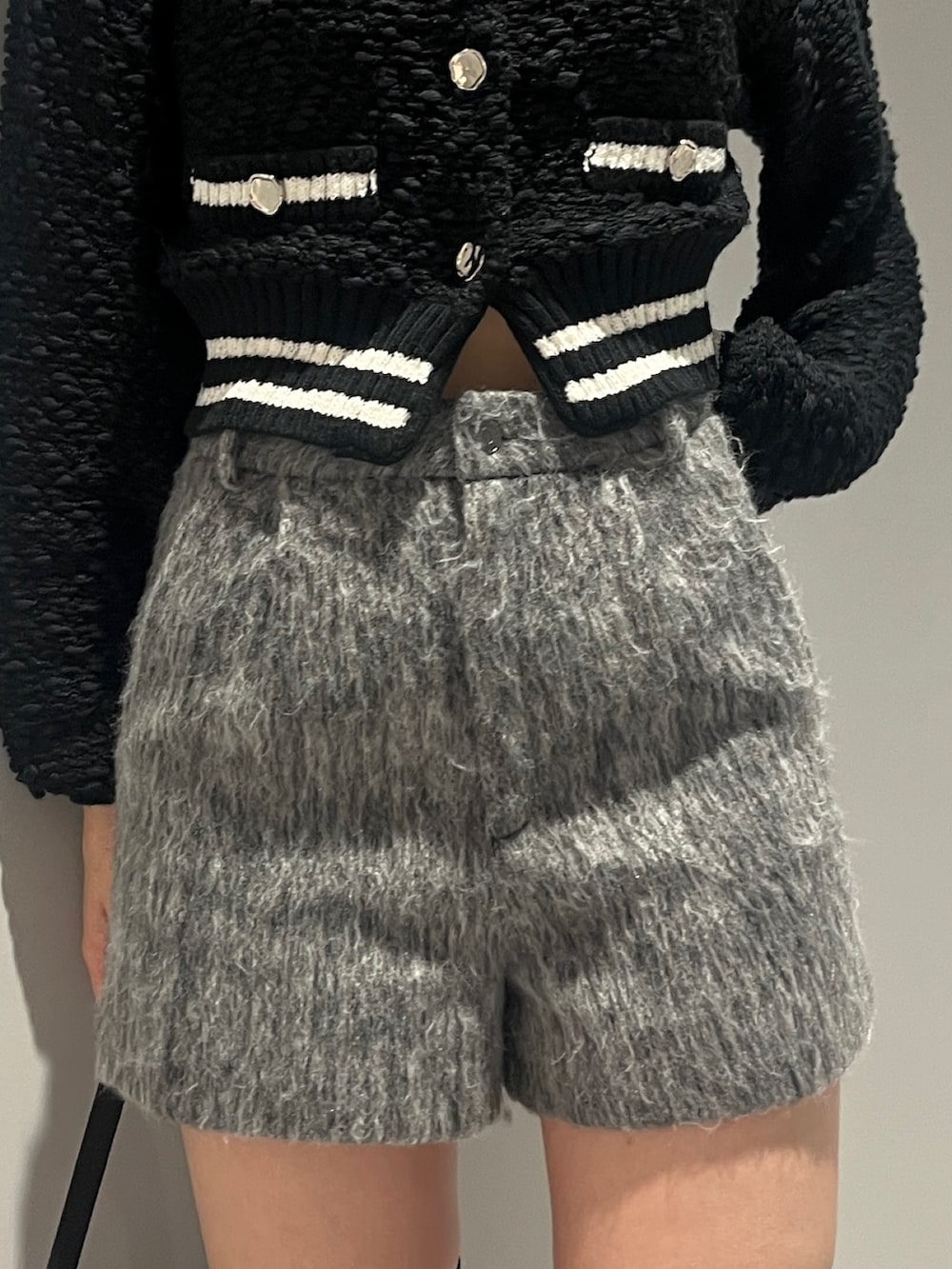 ホワイト系のブルゾン、ブラック系のカーディガン/ボレロ、グレー系のその他パンツを着用したレディースの冬コーディネートの8枚目の写真