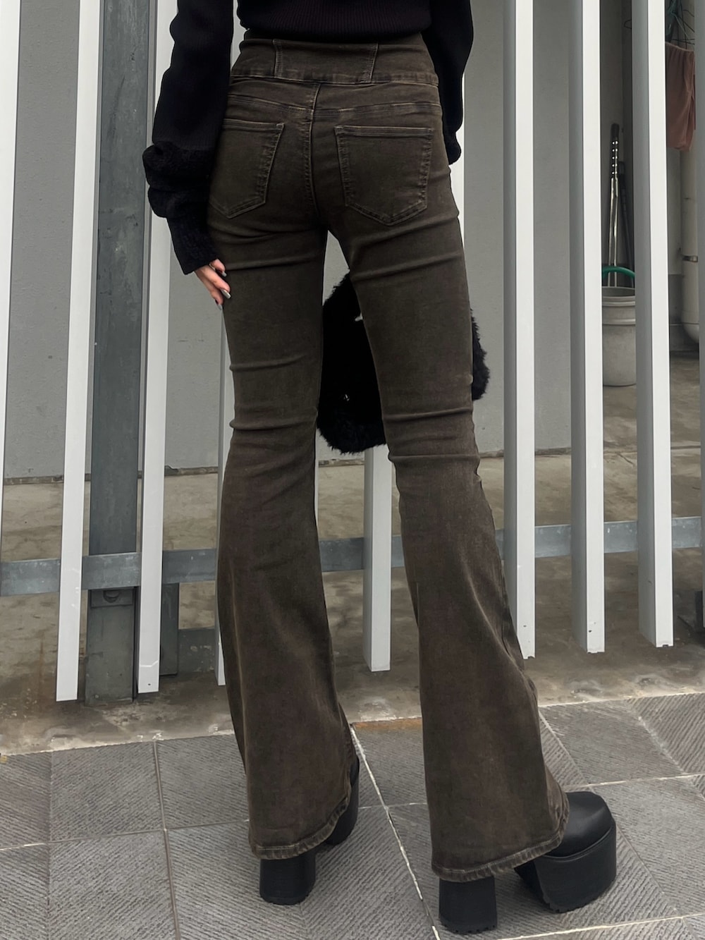 ブラック系のデニムパンツ、ブラウン系のブルゾン、ブラック系のハンドバッグを着用したレディースの秋コーディネートの8枚目の写真