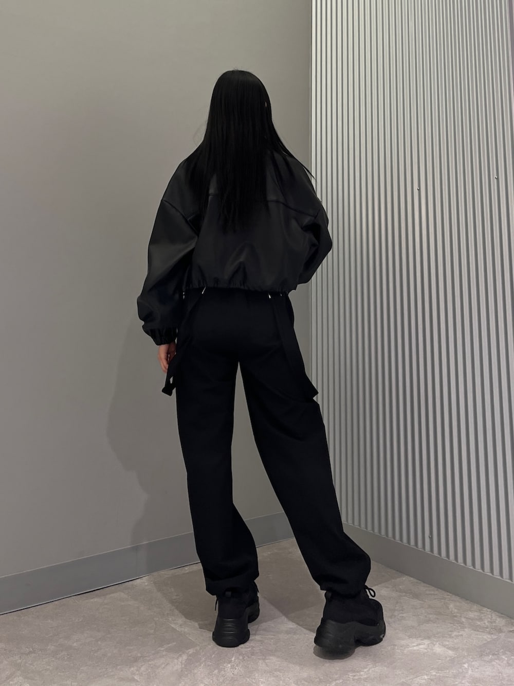 ブラック系のブルゾン、グリーン系のキャミソール、ブラック系のその他パンツを着用したレディースの冬コーディネートの3枚目の写真