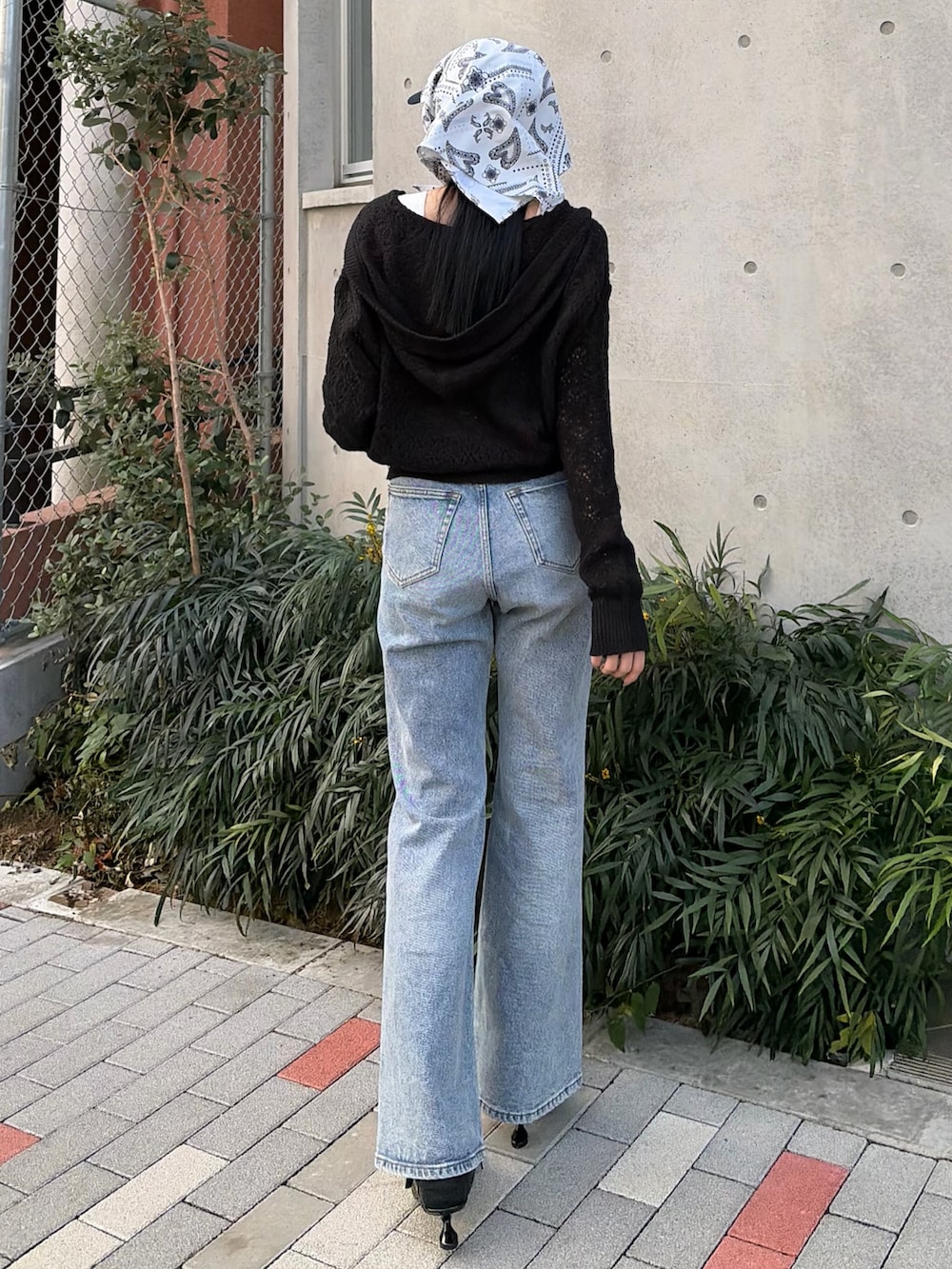 ブラック系のパーカー、ホワイト系のニット/セーター、ブルー系のデニムパンツを着用したレディースの春コーディネートの3枚目の写真