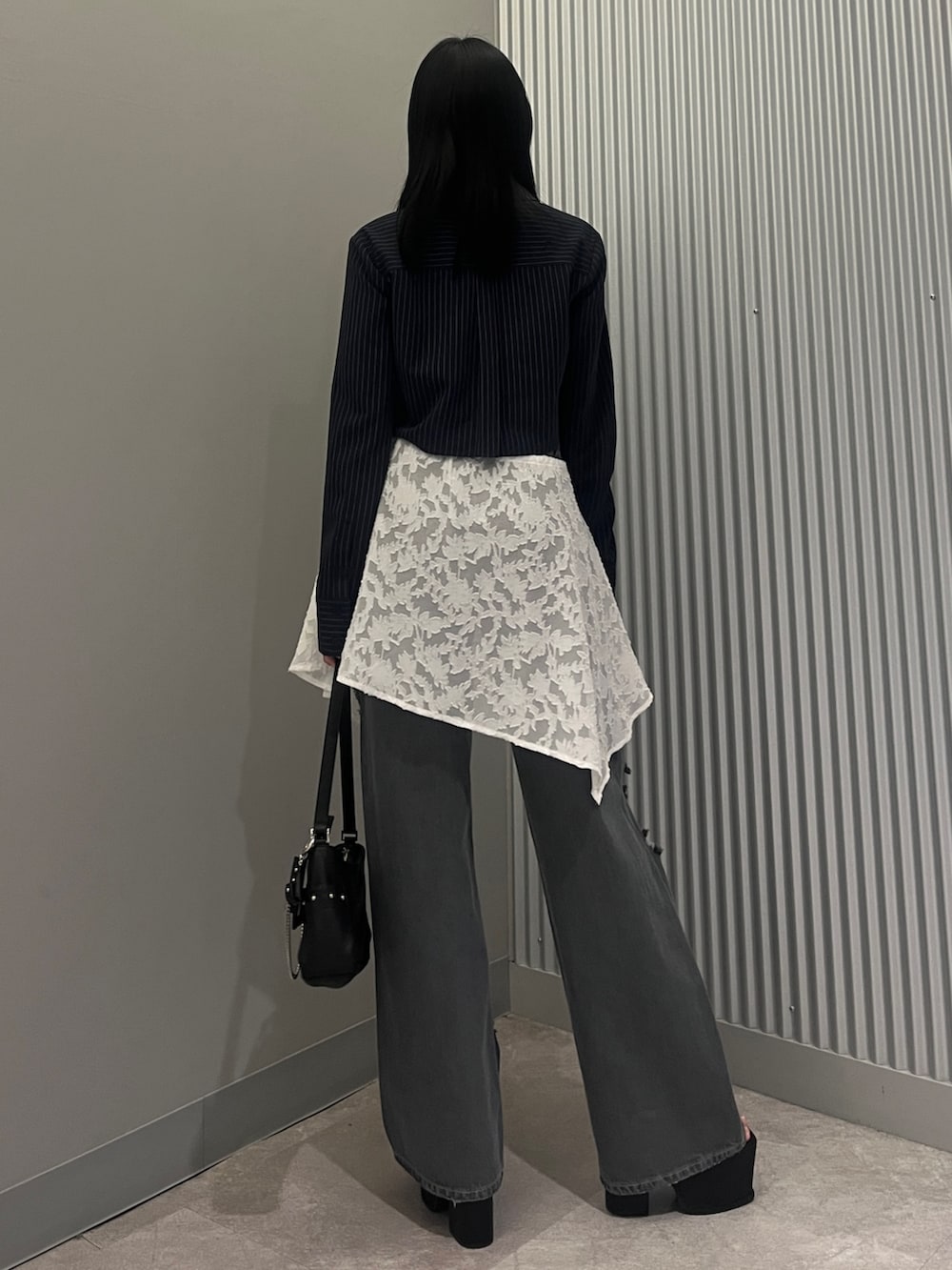 ブルー系のシャツ/ブラウス、ブラック系のハンドバッグ、ホワイト系のスカートを着用したレディースの春コーディネートの3枚目の写真