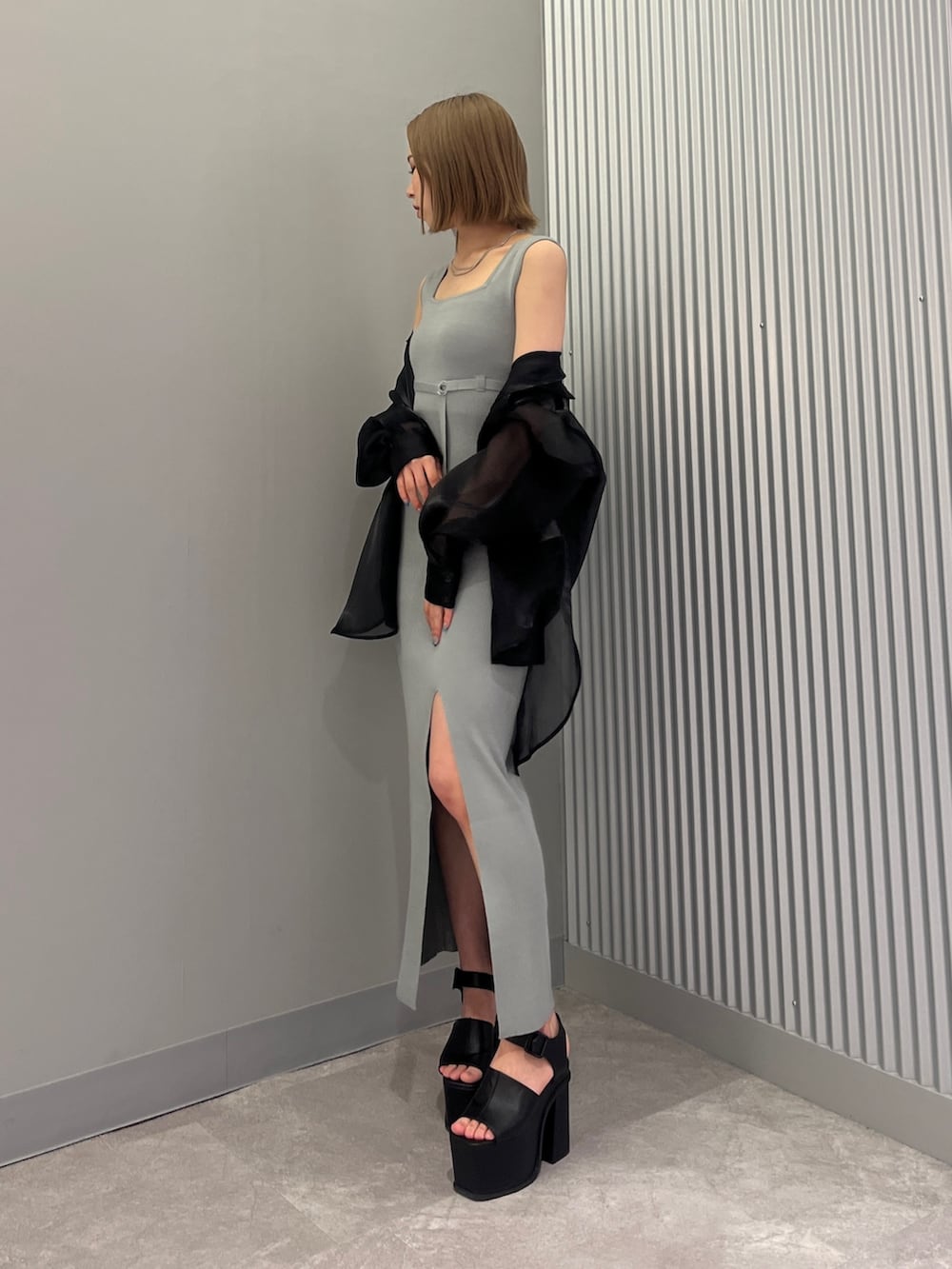 ブルー系のワンピース、ブラック系のサンダル、ブラック系のシャツ/ブラウスを着用したレディースの春コーディネートの2枚目の写真