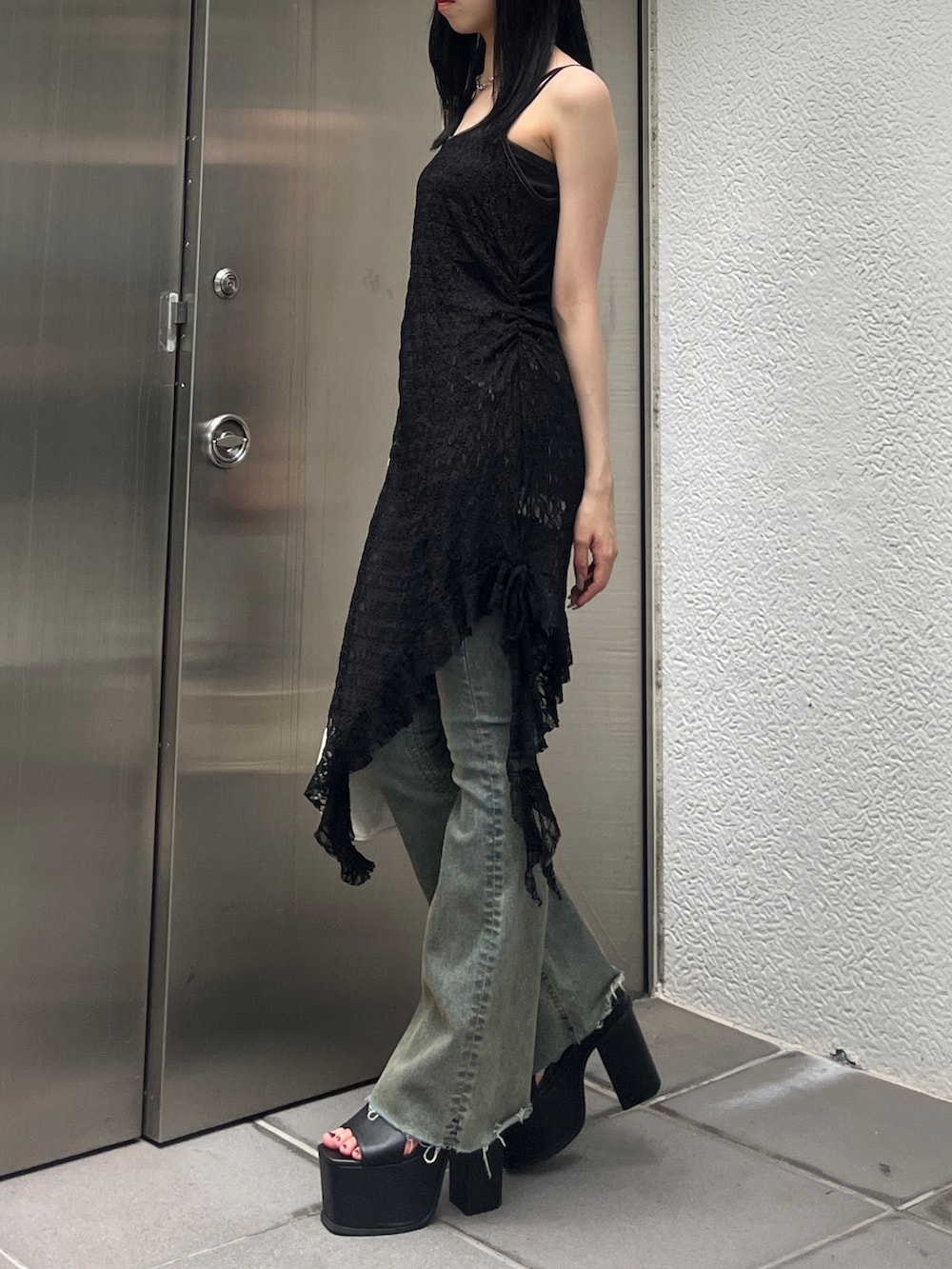 ブルー系のデニムパンツ、ホワイト系のショルダーバッグ、ブラック系のサンダルを着用したレディースの夏コーディネートの2枚目の写真