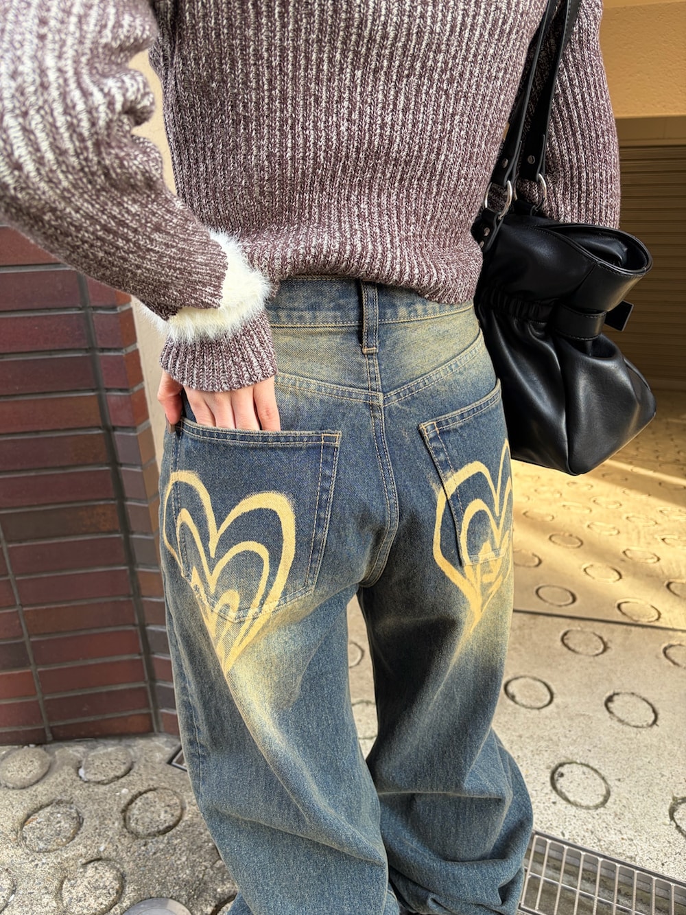 ブラウン系のニット/セーター、ブルー系のデニムパンツ、ブラック系のブーツを着用したレディースの冬コーディネートの5枚目の写真