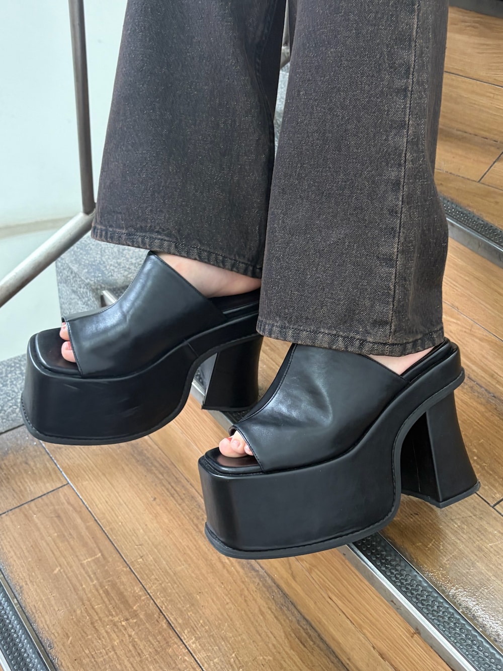 ブルー系のデニムパンツ、ブラック系のサンダル、ホワイト系のキャミソールを着用したレディースの春コーディネートの7枚目の写真