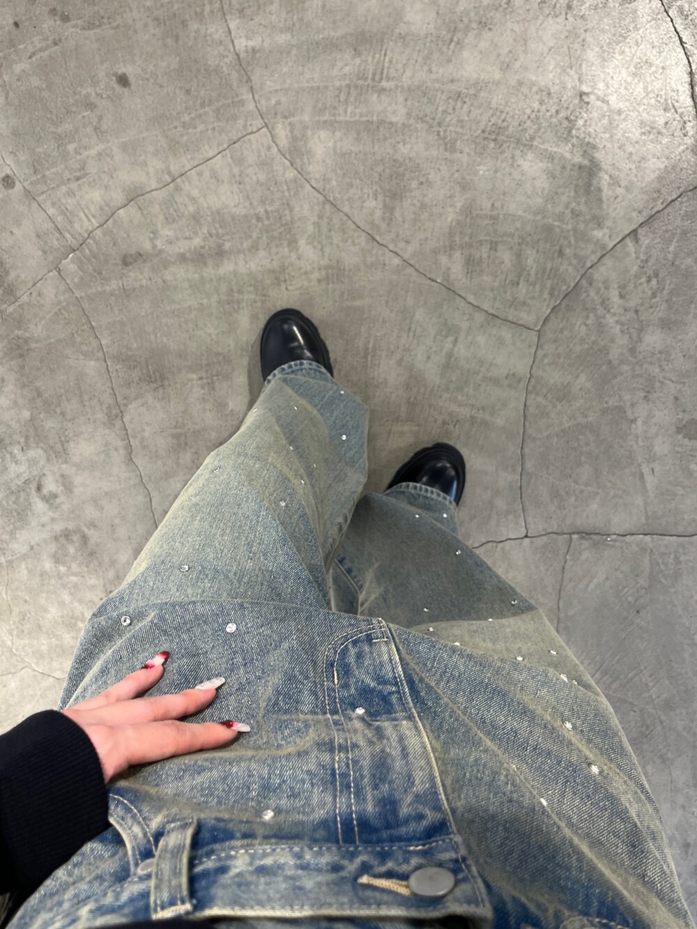 ブラック系のパーカー、ブルー系のデニムパンツ、ブラック系のハンドバッグを着用したレディースの秋コーディネートの5枚目の写真