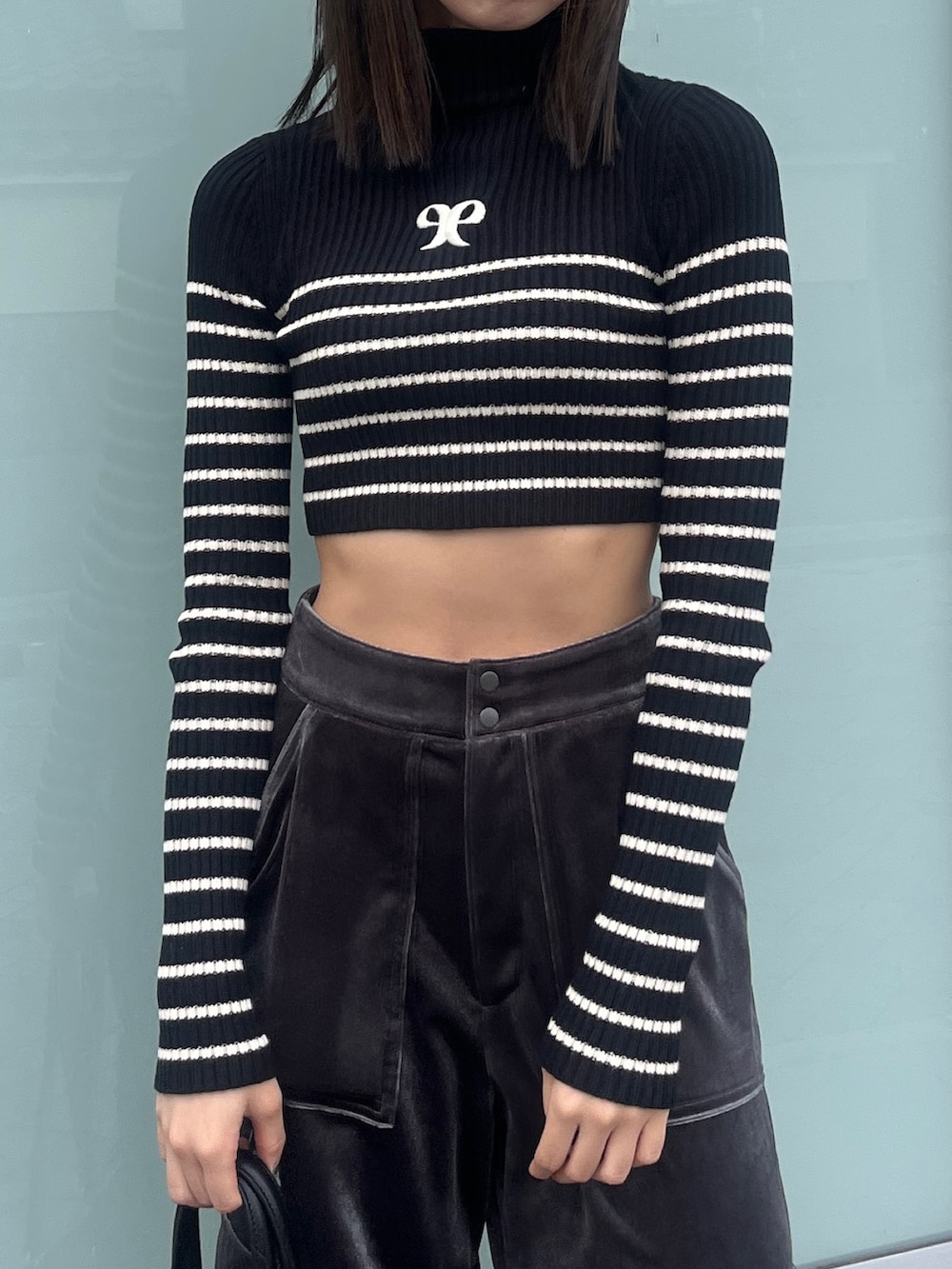 ブラック系のニット/セーター、ブラック系のブルゾン、グレー系のカーゴパンツを着用したレディースの秋コーディネートの7枚目の写真