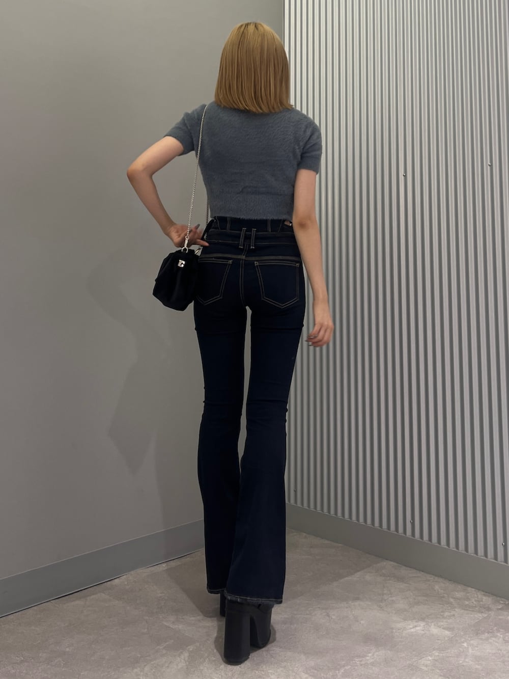 ブルー系のニット/セーター、ブルー系のデニムパンツ、ブラック系のサンダルを着用したレディースの夏コーディネートの3枚目の写真