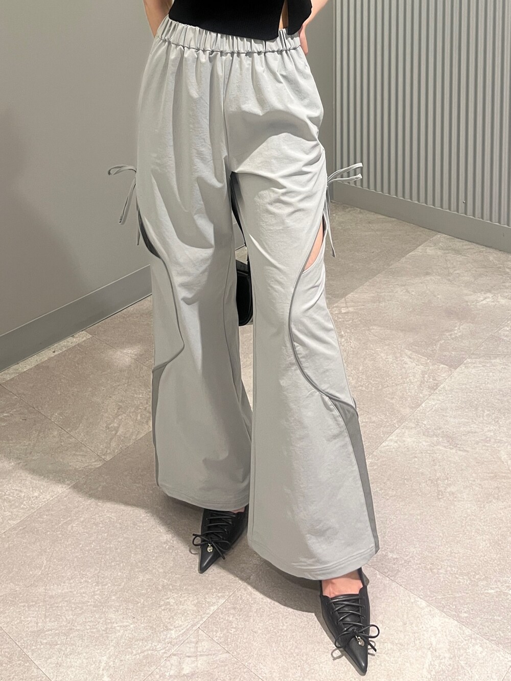 ブラック系のショルダーバッグ、グレー系のその他パンツ、ブラック系のパンプスを着用したレディースの夏コーディネートの5枚目の写真