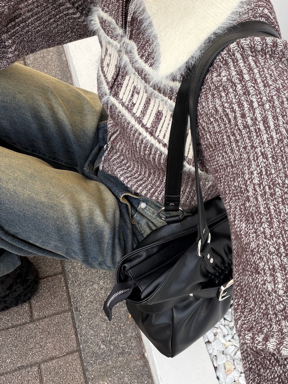 ブラウン系のニット/セーター、ブルー系のデニムパンツ、ブラック系のブーツを着用したレディースの冬コーディネートの6枚目の写真