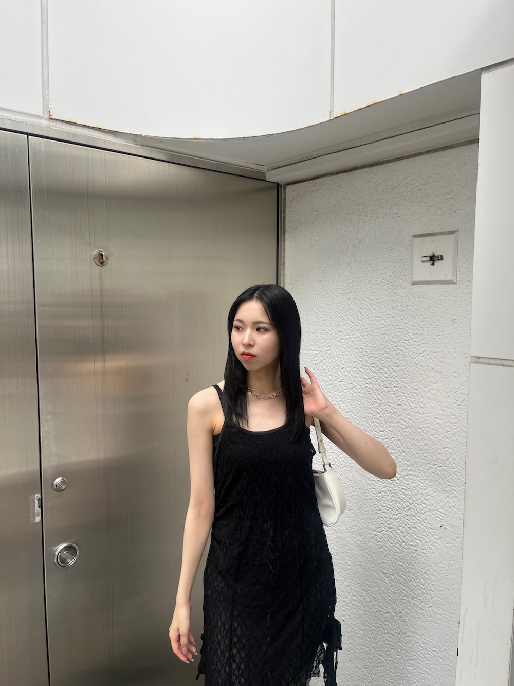 ブルー系のデニムパンツ、ホワイト系のショルダーバッグ、ブラック系のサンダルを着用したレディースの夏コーディネートの5枚目の写真