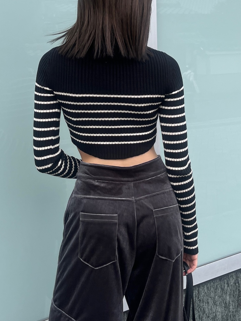 ブラック系のニット/セーター、ブラック系のブルゾン、グレー系のカーゴパンツを着用したレディースの秋コーディネートの8枚目の写真