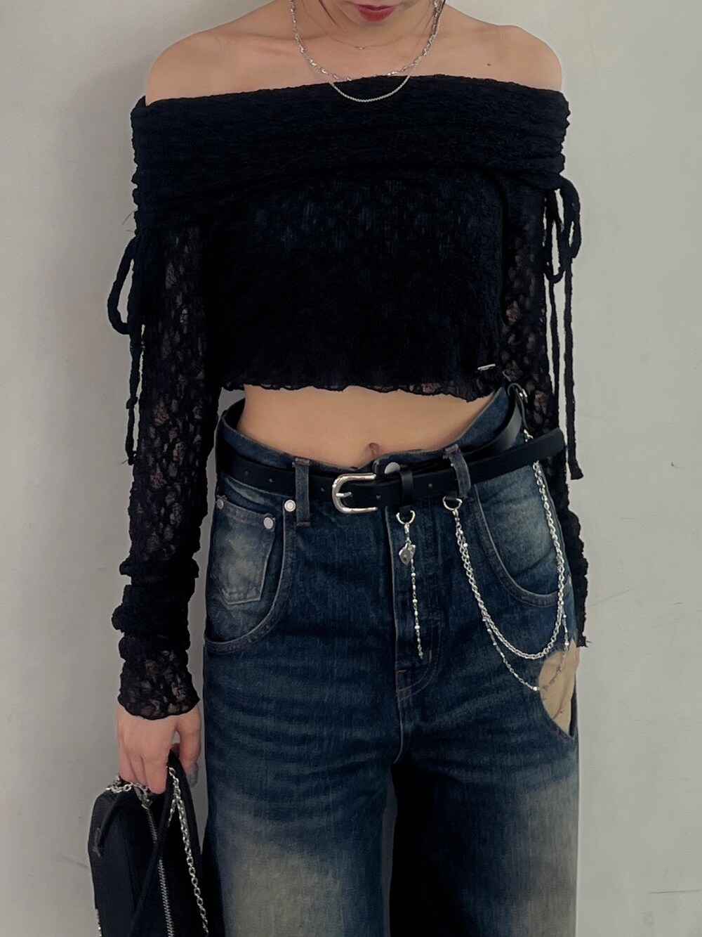 ブラック系のTシャツ/カットソー、ブルー系のデニムパンツ、ブラック系のブーツを着用したレディースの秋コーディネートの5枚目の写真