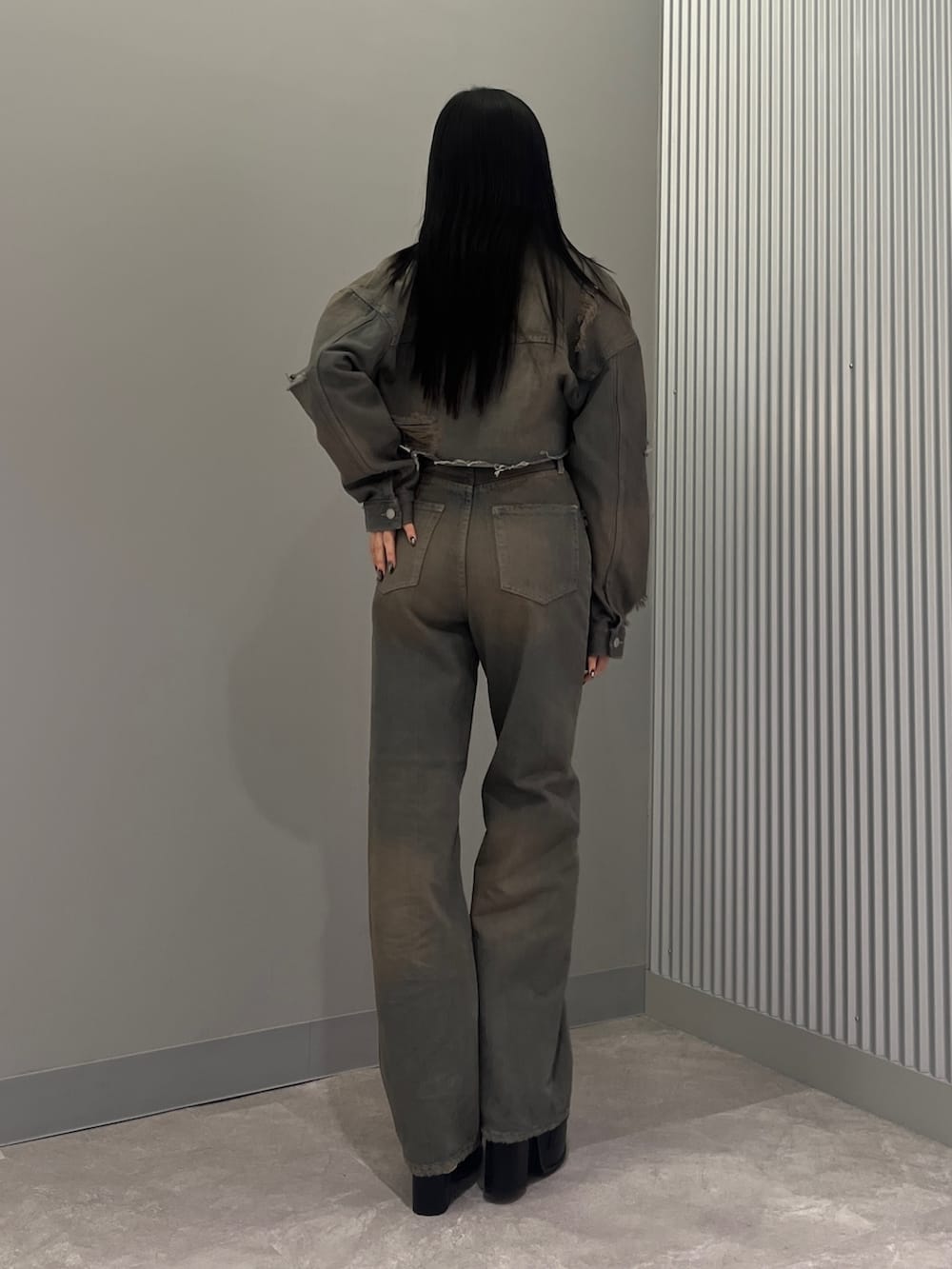 グレー系のデニムパンツ、ブラック系のサンダル、グレー系のデニムジャケットを着用したレディースの冬コーディネートの3枚目の写真