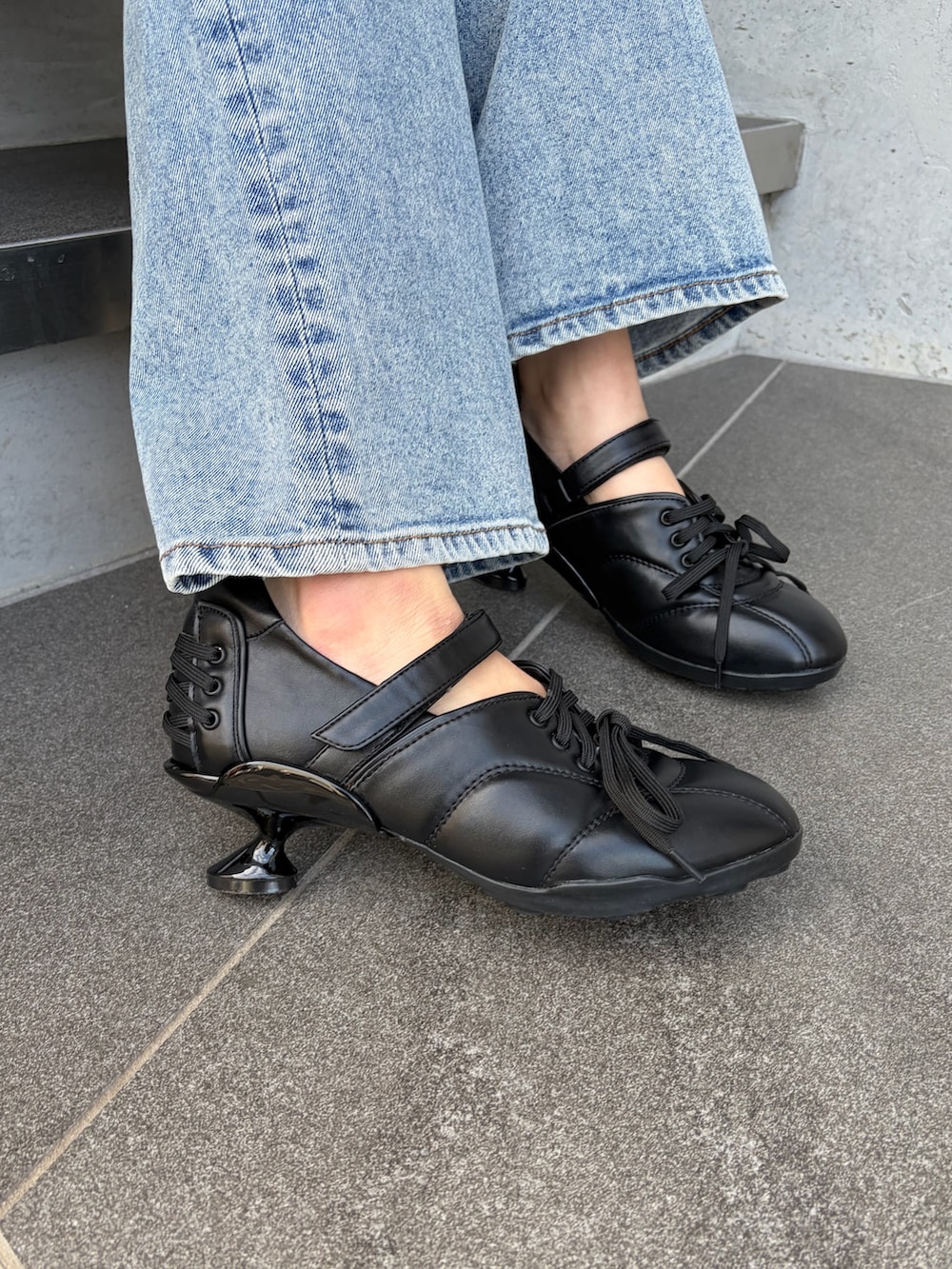 ブラック系のパーカー、ホワイト系のニット/セーター、ブルー系のデニムパンツを着用したレディースの春コーディネートの5枚目の写真