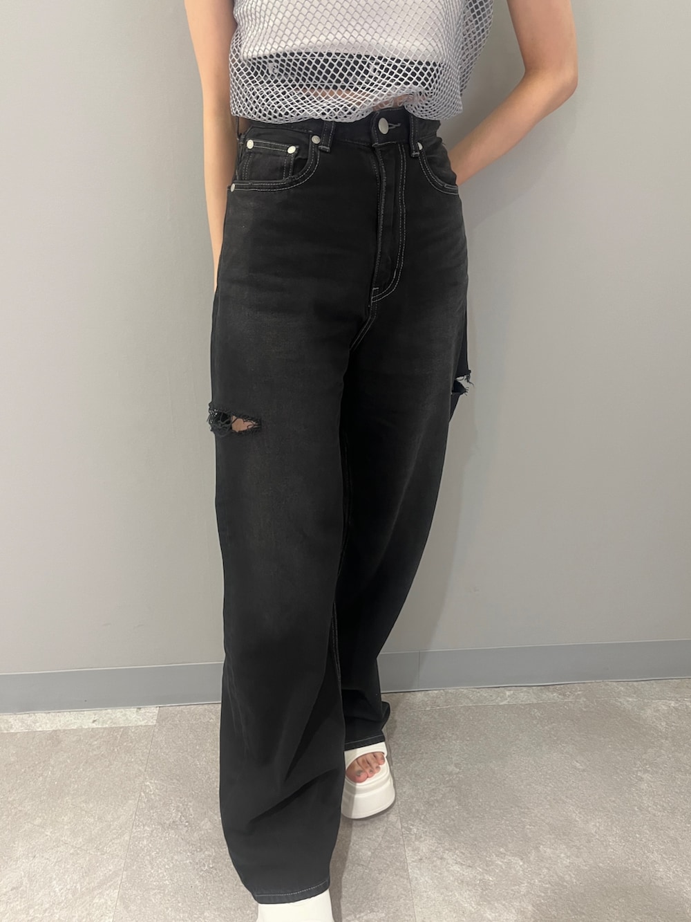 ブラック系のデニムパンツ、グレー系のTシャツ/カットソー、ホワイト系のサンダルを着用したレディースの夏コーディネートの7枚目の写真