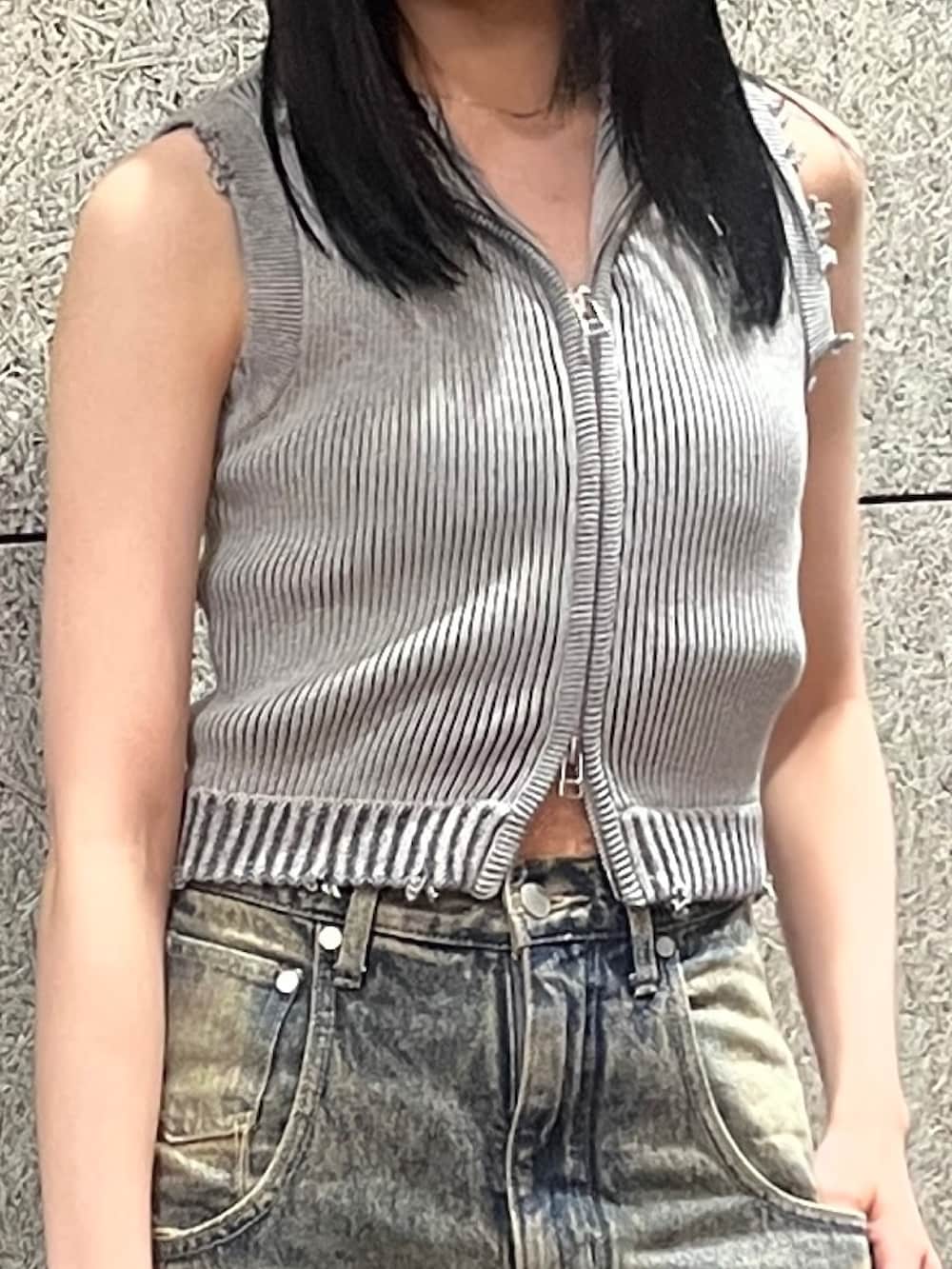 グレー系のタンクトップ、ブルー系のデニムパンツ、ブラック系のハンドバッグを着用したレディースの春コーディネートの4枚目の写真