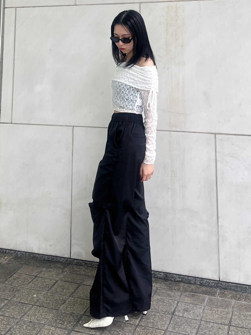 ブラック系のその他パンツ、ブラック系のハンドバッグ、ホワイト系のパンプスを着用したレディースの春コーディネートの2枚目の写真