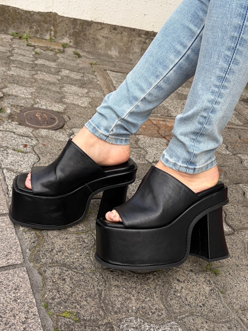 ブルー系のデニムパンツ、ブラック系のサンダルを着用したレディースの春コーディネートの6枚目の写真