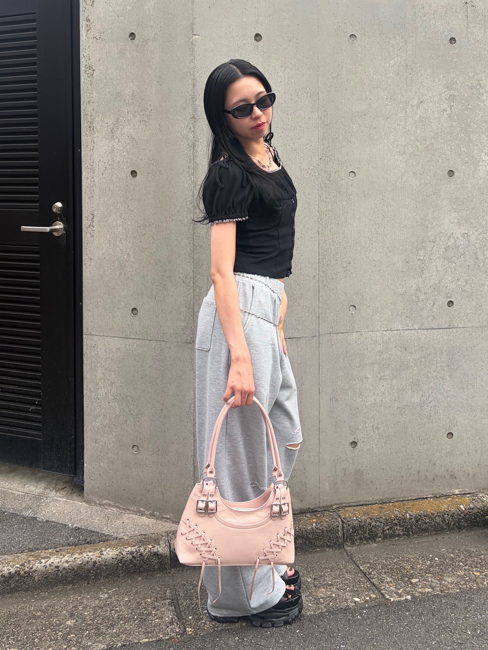 グレー系のスウェットパンツ、ブラック系のTシャツ/カットソー、ピンク系のショルダーバッグを着用したレディースの夏コーディネートの2枚目の写真
