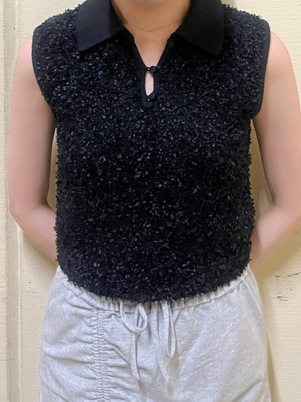 ブラック系のニット/セーター、グレー系のスカート、ブラック系のサンダルを着用したレディースの夏コーディネートの7枚目の写真