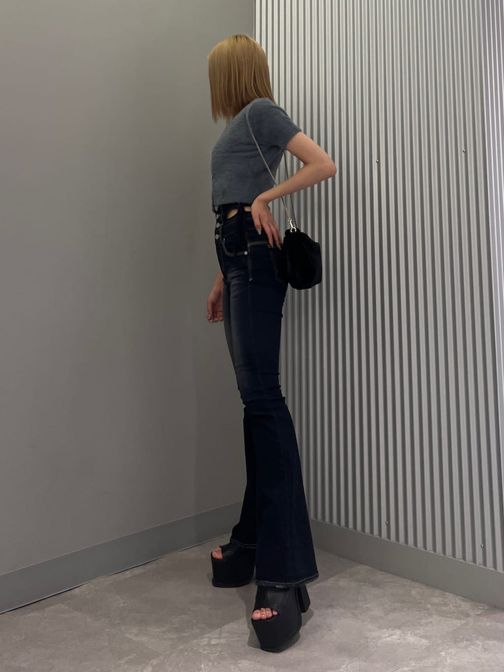 ブルー系のニット/セーター、ブルー系のデニムパンツ、ブラック系のサンダルを着用したレディースの夏コーディネートの2枚目の写真