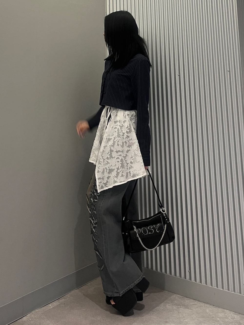 ブルー系のシャツ/ブラウス、ブラック系のハンドバッグ、ホワイト系のスカートを着用したレディースの春コーディネートの2枚目の写真