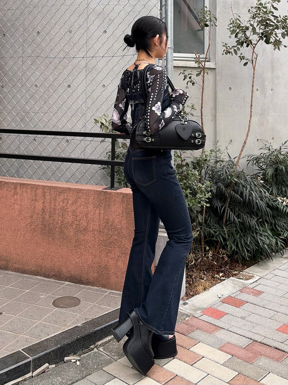 ブラック系のハンドバッグ、ブルー系のサロペット/オーバーオール、ブルー系のTシャツ/カットソーを着用したレディースの春コーディネートの2枚目の写真