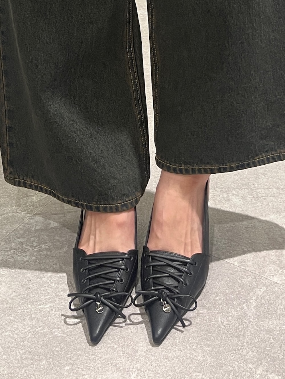ブルー系のデニムパンツ、ブルー系のベスト、ブラック系のTシャツ/カットソーを着用したレディースの春コーディネートの5枚目の写真