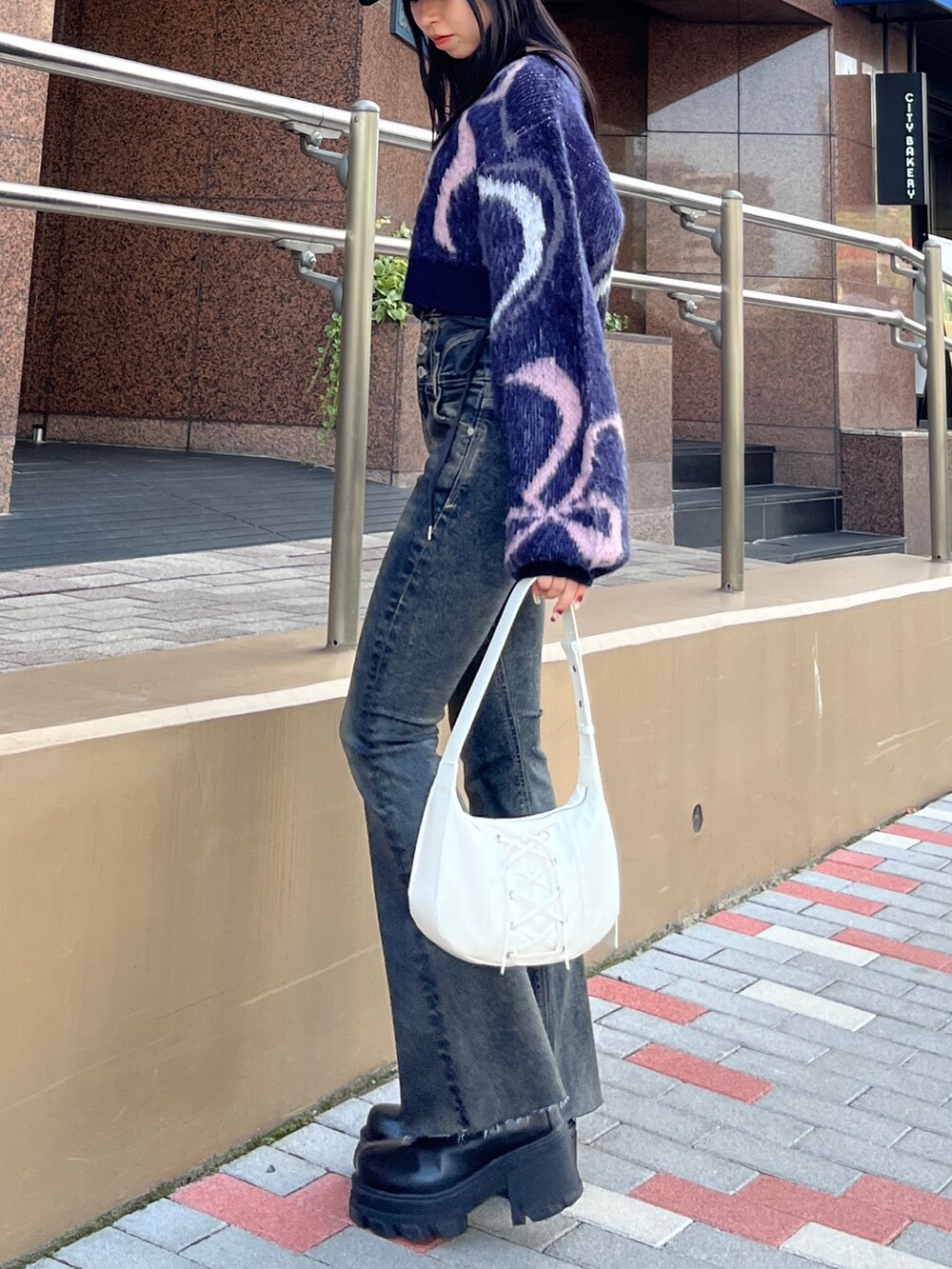 ブルー系のニット/セーター、ブルー系のデニムパンツ、ホワイト系のショルダーバッグを着用したレディースの秋コーディネートの3枚目の写真