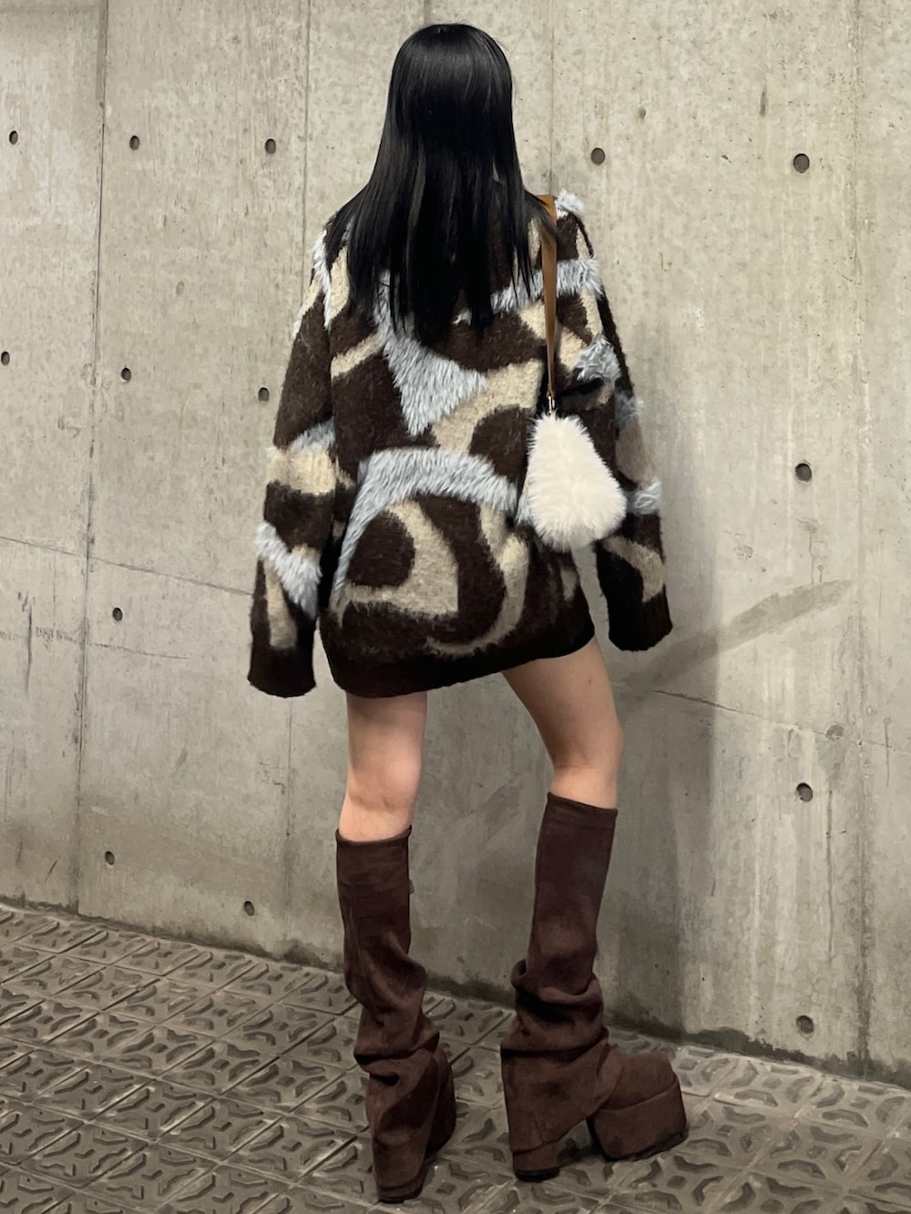 ブラウン系のニット/セーター、ブラウン系のブーツ、ホワイト系のショルダーバッグを着用したレディースの秋コーディネートの3枚目の写真