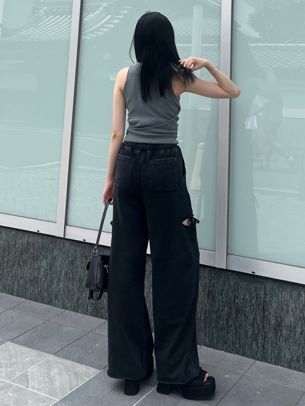 グレー系のTシャツ/カットソー、ブラック系のスウェットパンツ、ブラック系のハンドバッグを着用したレディースの夏コーディネートの2枚目の写真