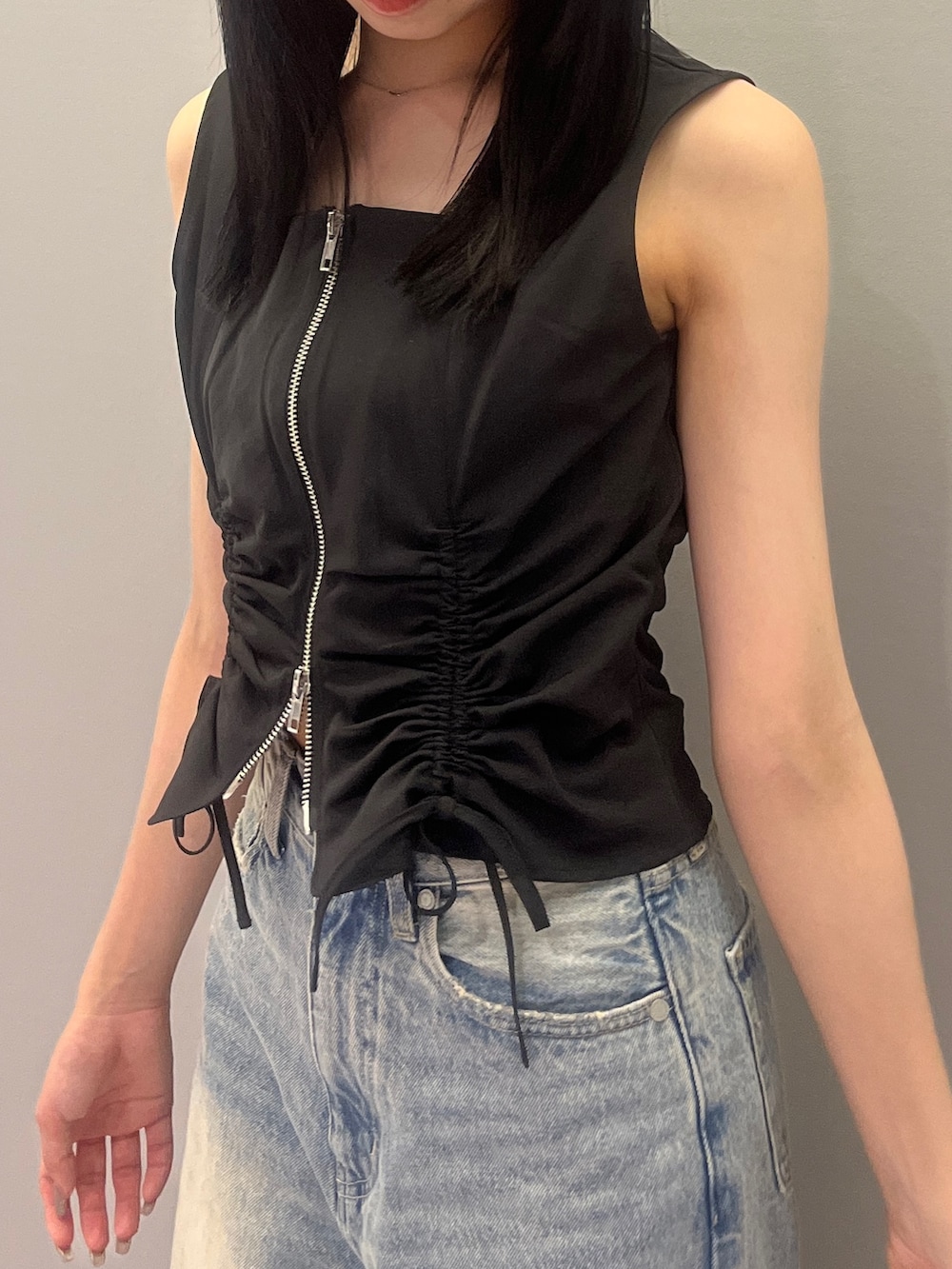 ブルー系のデニムパンツ、ホワイト系のハンドバッグ、ブラック系のTシャツ/カットソーを着用したレディースの夏コーディネートの4枚目の写真