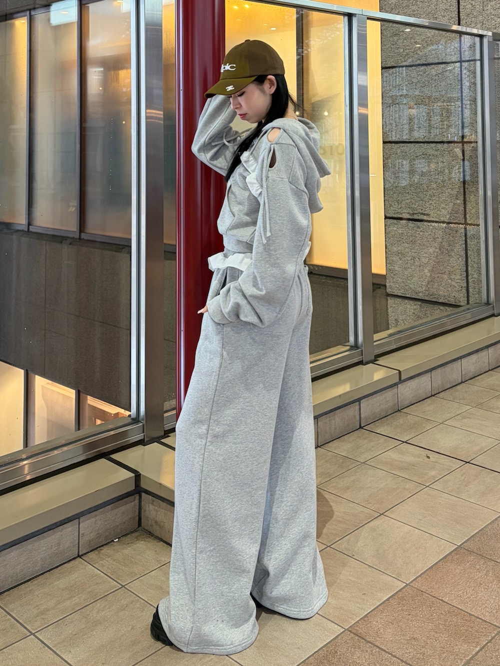 グレー系のスウェットパンツ、グレー系のパーカー、ブラック系のブーツを着用したレディースの冬コーディネートの2枚目の写真