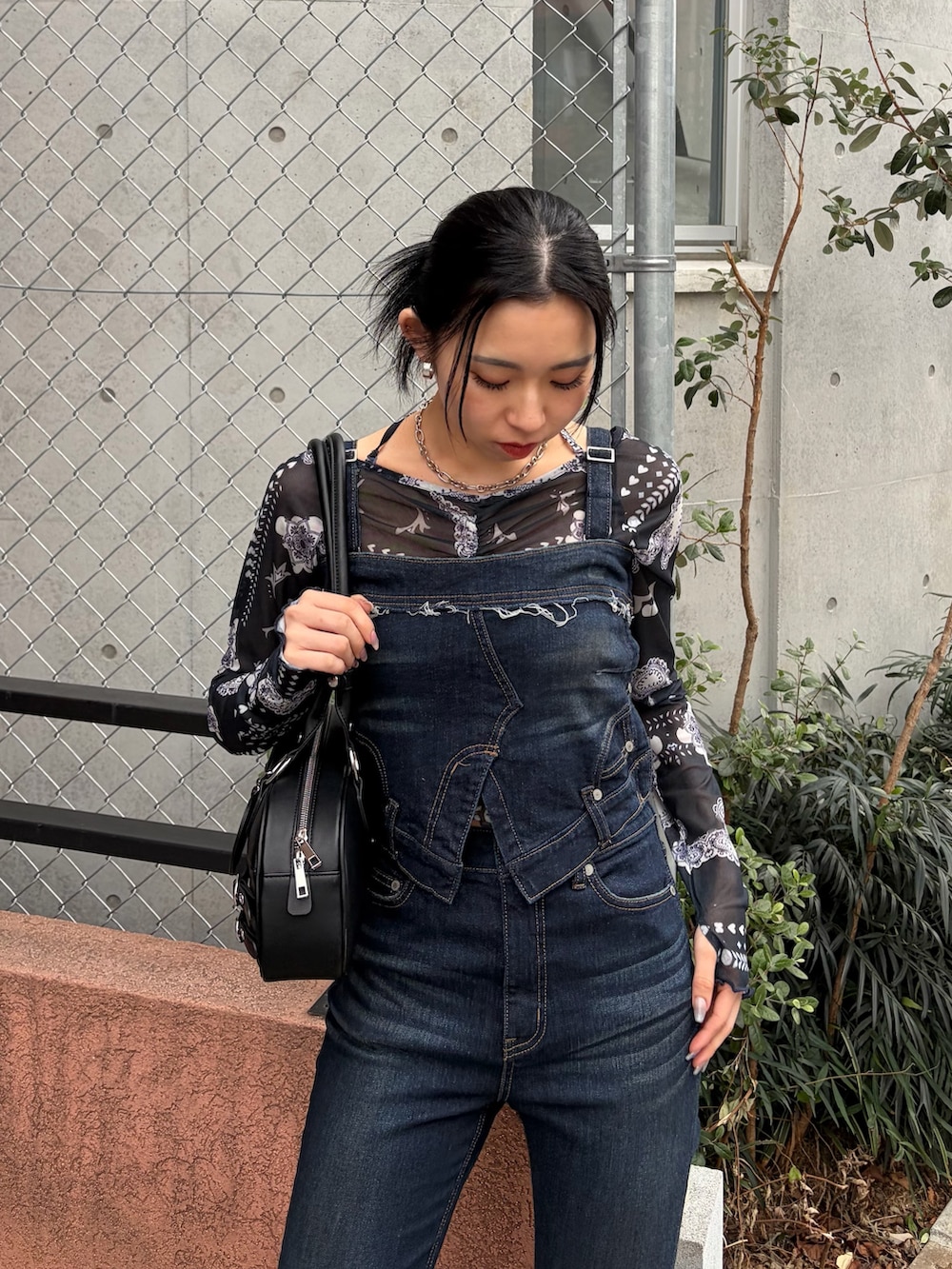 ブラック系のハンドバッグ、ブルー系のサロペット/オーバーオール、ブルー系のTシャツ/カットソーを着用したレディースの春コーディネートの4枚目の写真