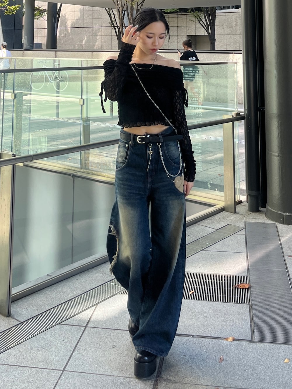 ブラック系のTシャツ/カットソー、ブルー系のデニムパンツ、ブラック系のブーツを着用したレディースの秋コーディネートの3枚目の写真