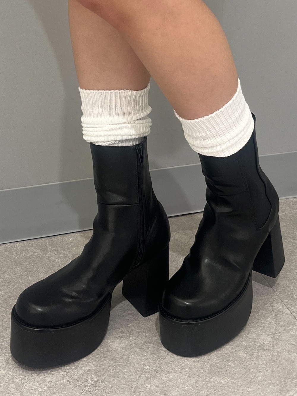 ブルー系のニット/セーター、ブラック系のデニムパンツ、ブラック系のショルダーバッグを着用したレディースの冬コーディネートの7枚目の写真