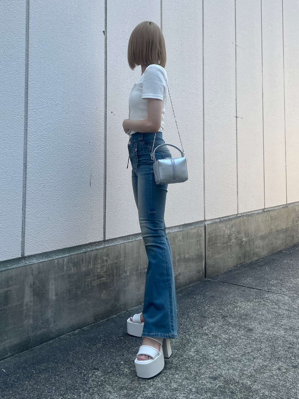 ホワイト系のTシャツ/カットソー、ブルー系のデニムパンツ、シルバー系のハンドバッグを着用したレディースの夏コーディネートの2枚目の写真